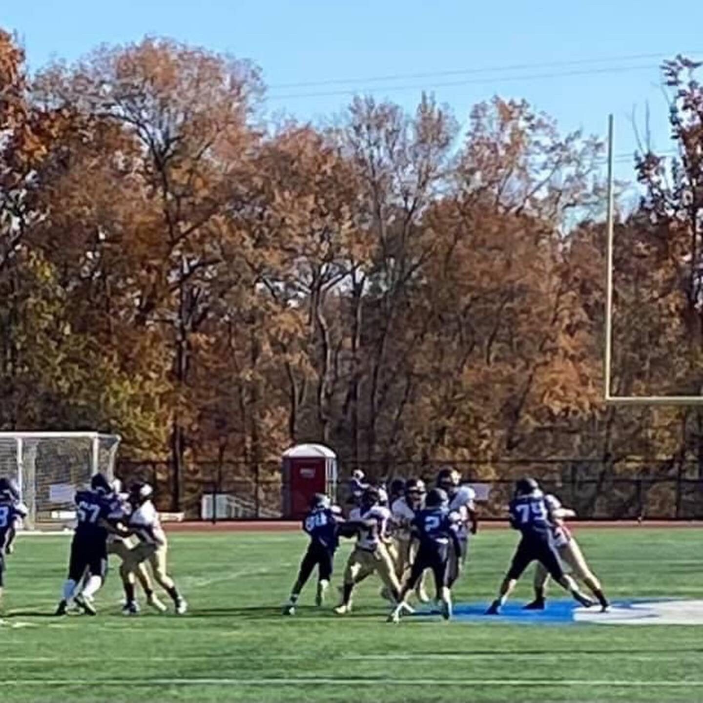 Tackle football players block and run during a play